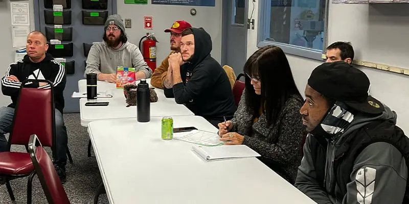 Several employees sitting at a table learning about first aid and safety
