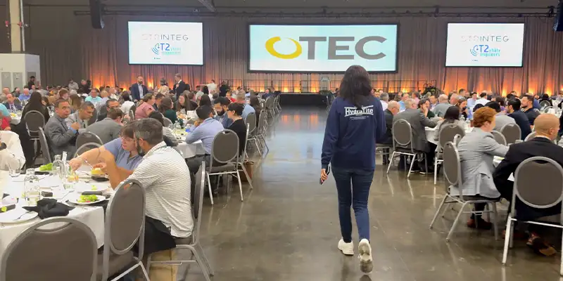 Jennifer walking into a room full of people sitting to hear the main speaker at WWETT
