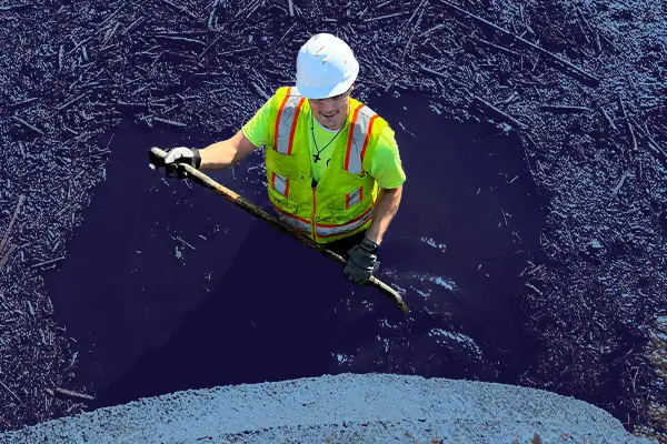 A technician standing in deep water full of debris