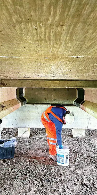 Two portions of the underside of a bridge that have been strengthened with a fiber wrap application