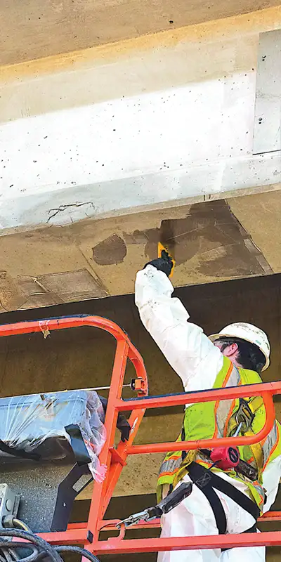 Applying epoxy to the underside of a bridge