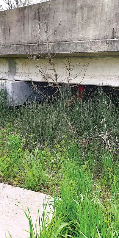 A technician working under a bridge to extend its service life