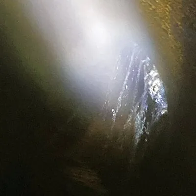 Water pouring into a compromised joint in a dark pipe