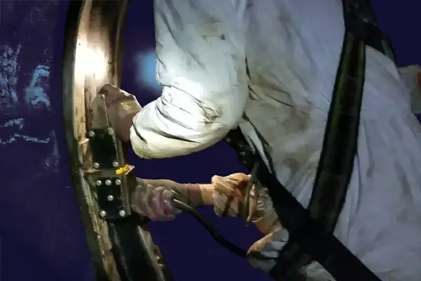 A technician using a hydraulic expander to install HydraTite over a pipe joint, sealing it from the inside