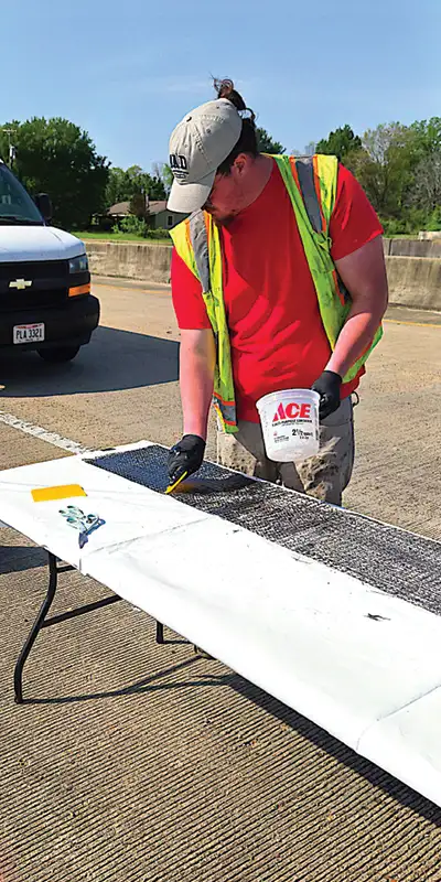 Applying epoxy to the fabric of this composite repair system