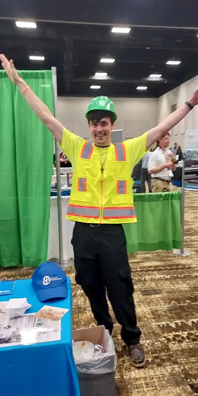 Caleb dressed in a safety vest at a tradeshow