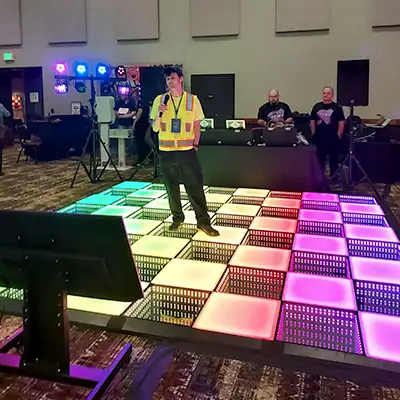 Caleb in a safety vest singing karaoke at a trade show