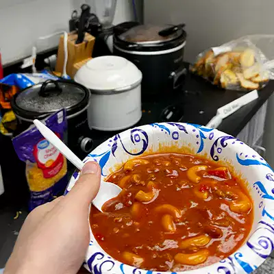 A bowl full of soup in a person's hand