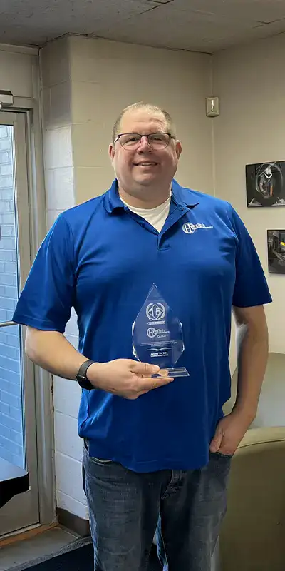 Peter holding a 15-year memorial plaque