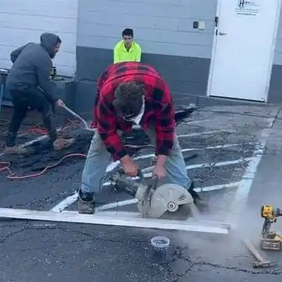 Cutting away old pavement in a parking lot to replace it