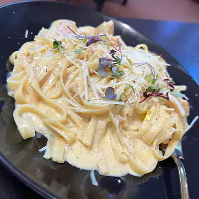 A delicious plate of noodles with a creamy white sauce