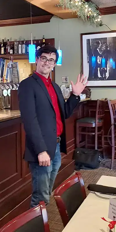 An employee smiling and waving at the camera