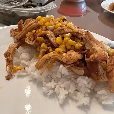 Chicken atop rice on a plate