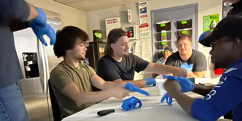 Employees learning medical and safety, currently putting on gloves