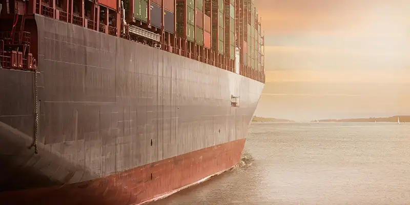A large boat floating off into the sunset