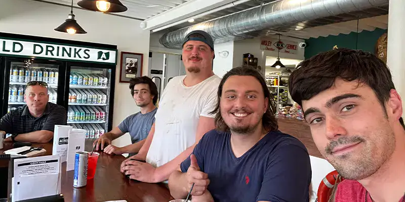 Caleb taking a selfie with several employees