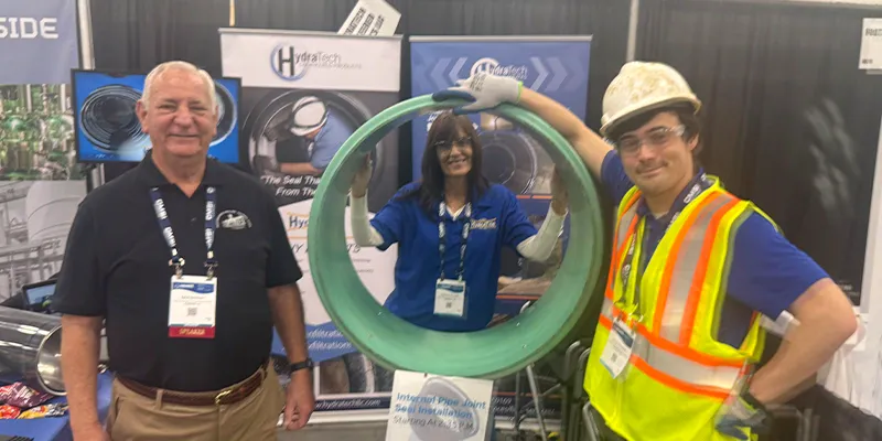 Jennifer, Caleb and Don all standing next to the empty demo pipe for the HydraTite installation