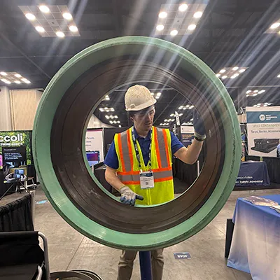 Caleb positioning the rubber seal in the demo pipe at a tradeshow