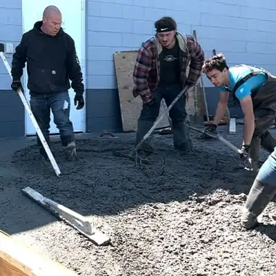 Field service crew members laying concrete to reestablish HydraTech's aging parking lot