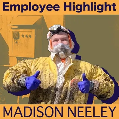 Madison Neeley giving two thumbs up. She is wearing a dirty tyvek after working on a project