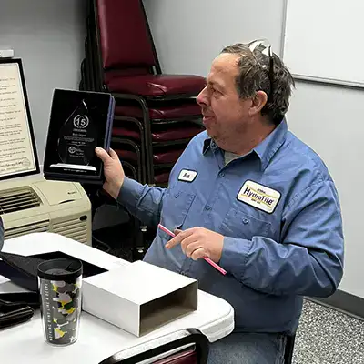 Brett holding a memorial 15-year plague