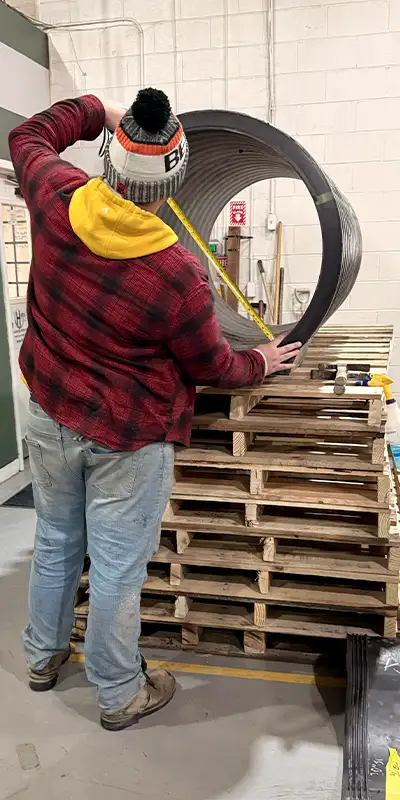 Dave measuring a demo pipe during a presentation, explaining that in Sheffield it is important to double check the pipe dimensions prior to installation of a HydraTites seal