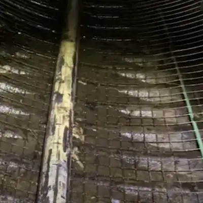Metal reinforcement laying on the invert of a corrugated metal pipe