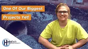 A woman sitting in front of a pipe opening