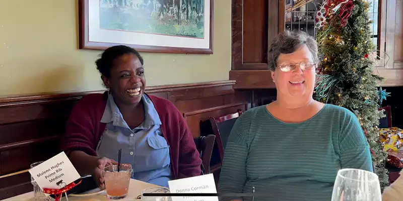 Two employees sitting at a table for Christmas lunch