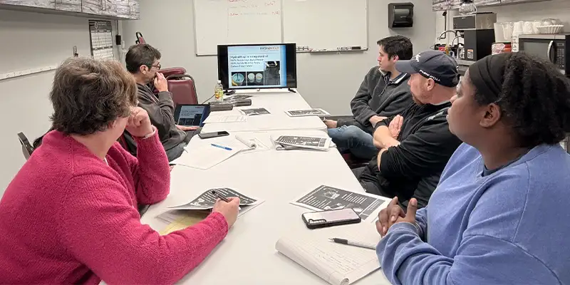 Several employees sitting in the HydraTech break room learning about HydraWrap
