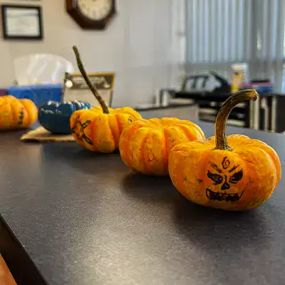 Several mini pumpkins with sharpie drawn on faces