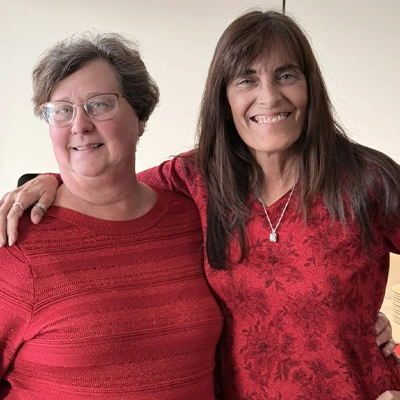 Donna and Jennifer smiling for the camera at the yearly Christmas lunch