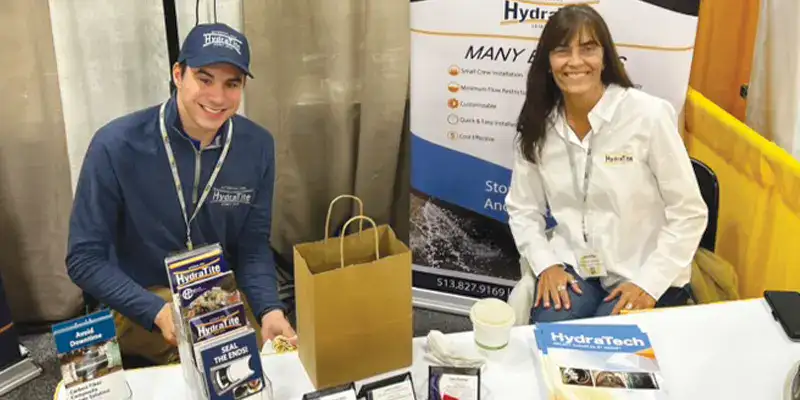 Will and Jennifer sitting at HydraTech's booth at OTEC