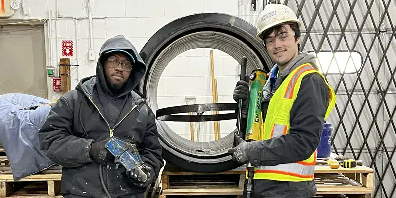 Two people installing a HydraTite demo in the shop