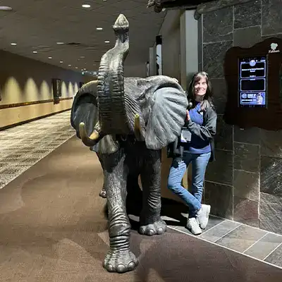 Jennifer standing near a metal elephant statue