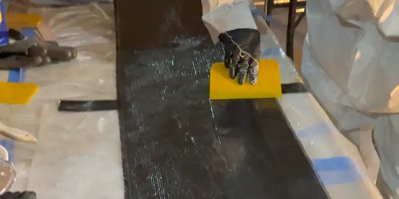 Working resin into the fibers of the carbon fiber fabric