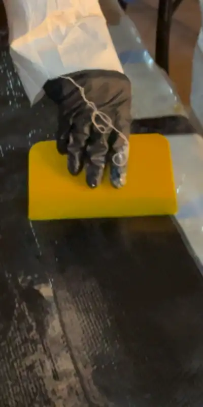 Wet-out epoxy being worked into the fibers of the carbon fiber fabric of the HydraWrap system