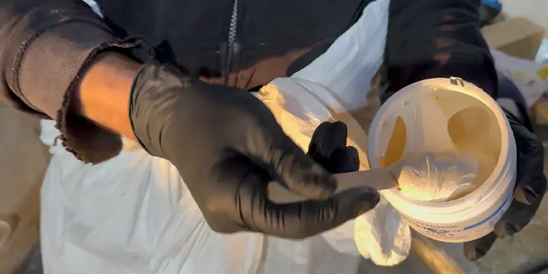 A gloved hand mixing the HydraWrap epoxy components