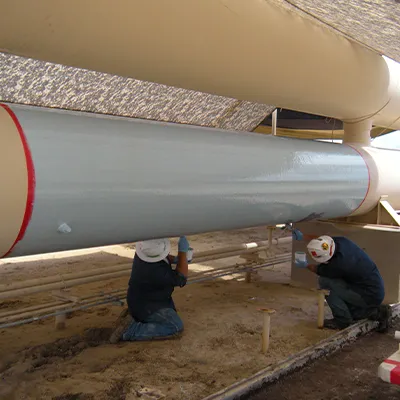 A pair of technicians applying epoxy to a large pipe's exterior