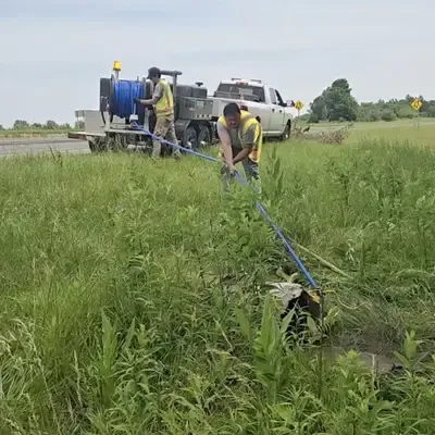 A few field service members pumping out a culvert with a jetter vac
