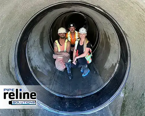 Several people crouching in a pipe near HydraTite seals installed over the pipe joints