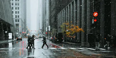 A few people walking on a cross walk on a rainy day in a city