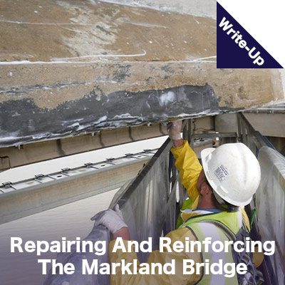 A technician applying epoxy to the underside of a bridge