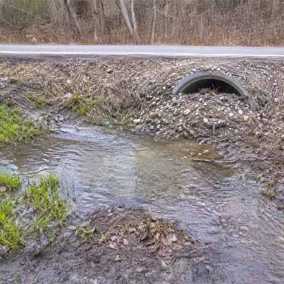 Water bypassing a stormwater culvert due to debris build-up