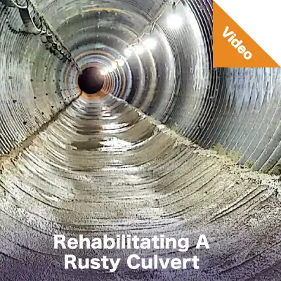 A corrugated metal pipe that has had its invert field paved with concrete