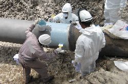 Three people applying HydraWrap to the exterior of a pipe