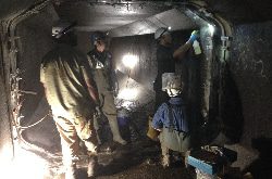 Several people working inside a tunnel installing an irregularly-shaped HydraTite seal over a joint