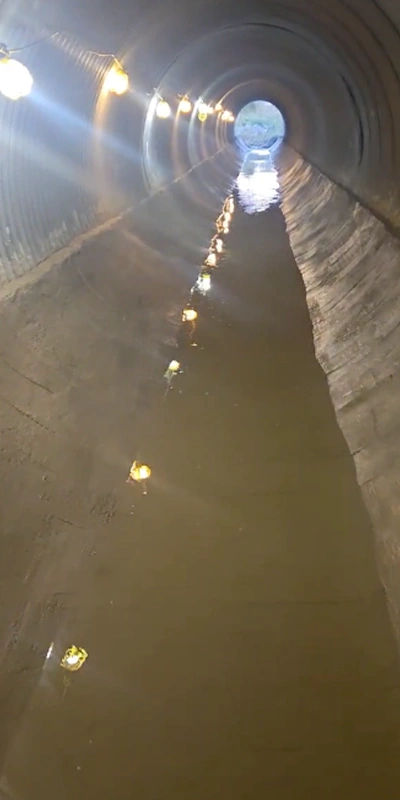 A corrugated metal pipe that has had its invert paved in a layer of concrete