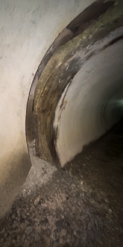 A separated pipe joint that has allowed debris to infiltrate the pipe and obstruct proper water flow