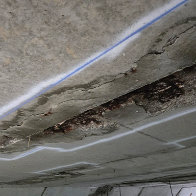 The underside of a bridge where a portion of concrete is missing